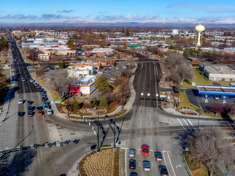 Aerial view of a busy urban intersection with cars, buildings, and a water tower in the background. water damage restoration in Meridian