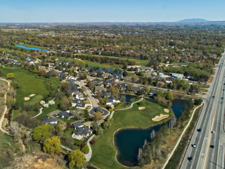 Aerial view of a suburban neighborhood with a golf course and a highway running alongside it. water damage restoration in Eagle