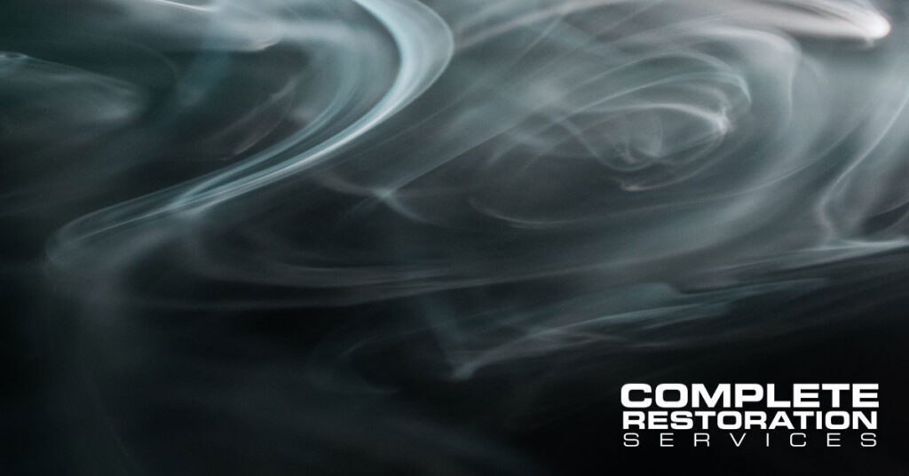 Swirling smoke on a dark background with the text "Complete Restoration Services" in the bottom right corner.